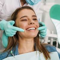 Patient smiling as the dentist shows her her teeth in the mirror